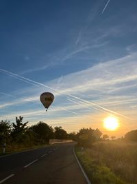Hei&szlig;luftballon am Himmer, Landstra&szlig;e und Sonnenuntergang.